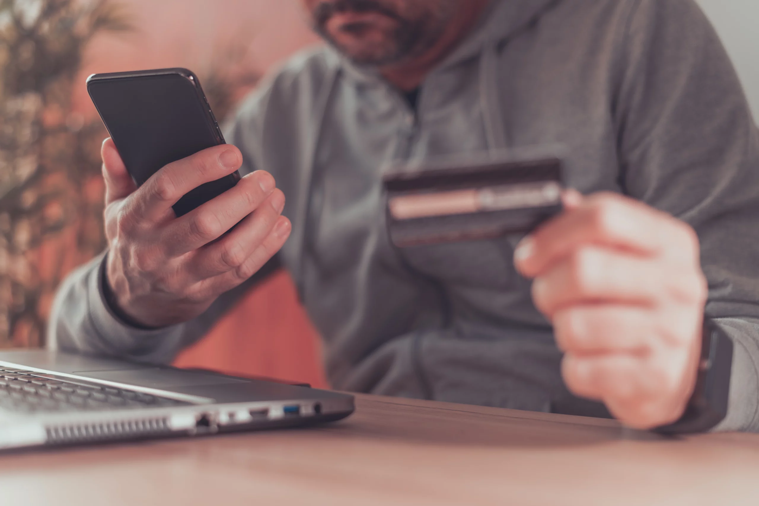 Man using smartphone and credit card while managing Venmo transactions in Tennessee